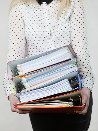 女子持用证件许多重彩粘合剂办公室，<i>簿</i>记对象的概念女人拿着沉重的多彩粘合剂与文件