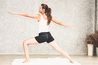 年轻<i>美</i><i>丽</i>的妇女在家做在地毯客厅的瑜伽锻炼健康的生活方式和放松