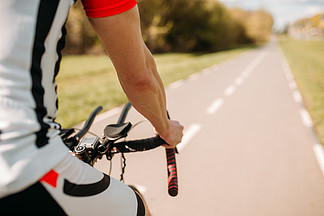 运动服的男性骑自行<i>车</i>者，循环在柏油路男运动员骑自行<i>车</i>在自行<i>车</i>道上锻炼在沥青路面上骑行的运动服的男性骑单<i>车</i>