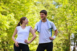 年轻健康夫妇做伸展运动放<i>松</i>，慢跑和在公园跑步后热身