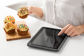 食物，计数<i>卡</i><i>路</i><i>里</i>和技术概念-使用片剂个人计算机计算机app，关闭妇女用杯形蛋糕Tablet pc和蛋糕的女人的特写