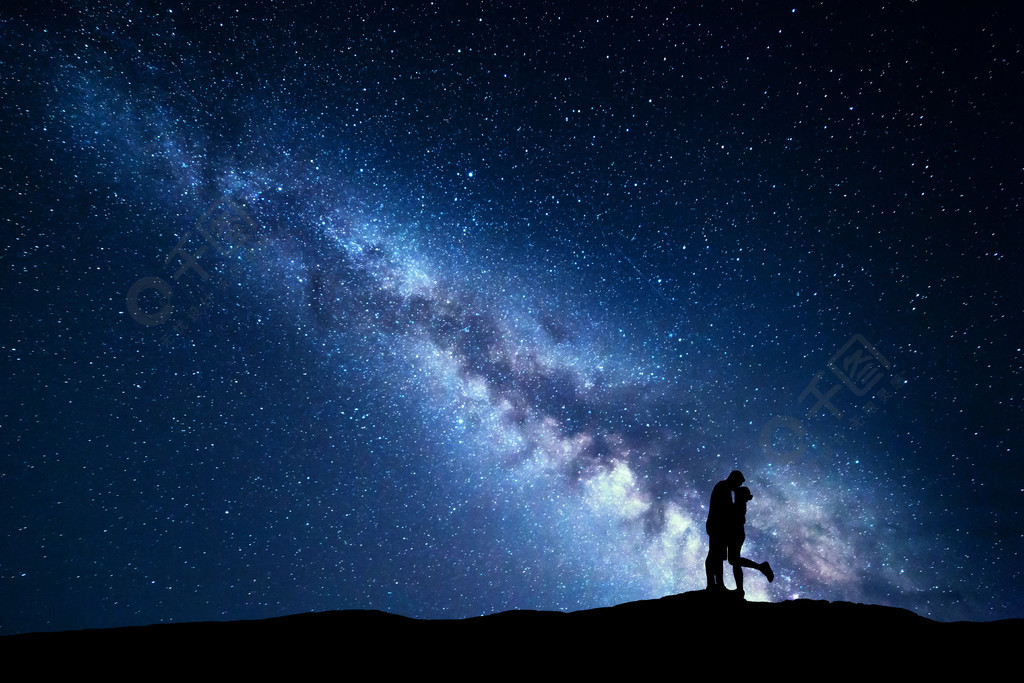 銀河在輪廓上的擁抱和親吻男人和女人在山上的夜景與星星的天空戀人的