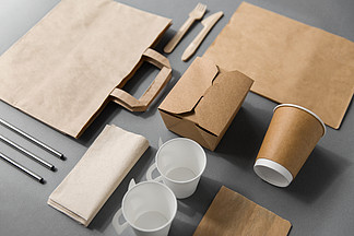 包装，回收和饮食概念-外卖食品的一次性纸容器与杯子，袋子，餐巾和利器在桌上一次性纸外卖食品包装材<i>料</i>