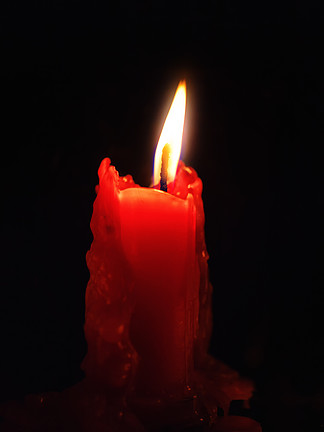 一支红蜡烛在黑暗特写中燃烧