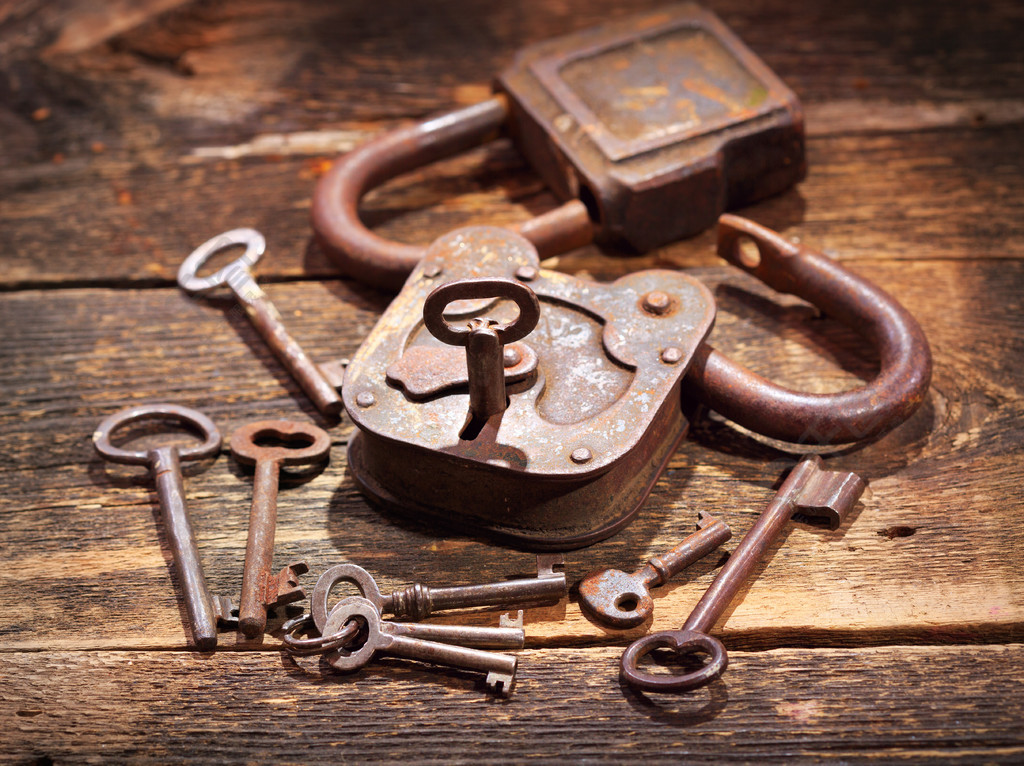 旧的生锈锁和木制的桌子上的钥匙