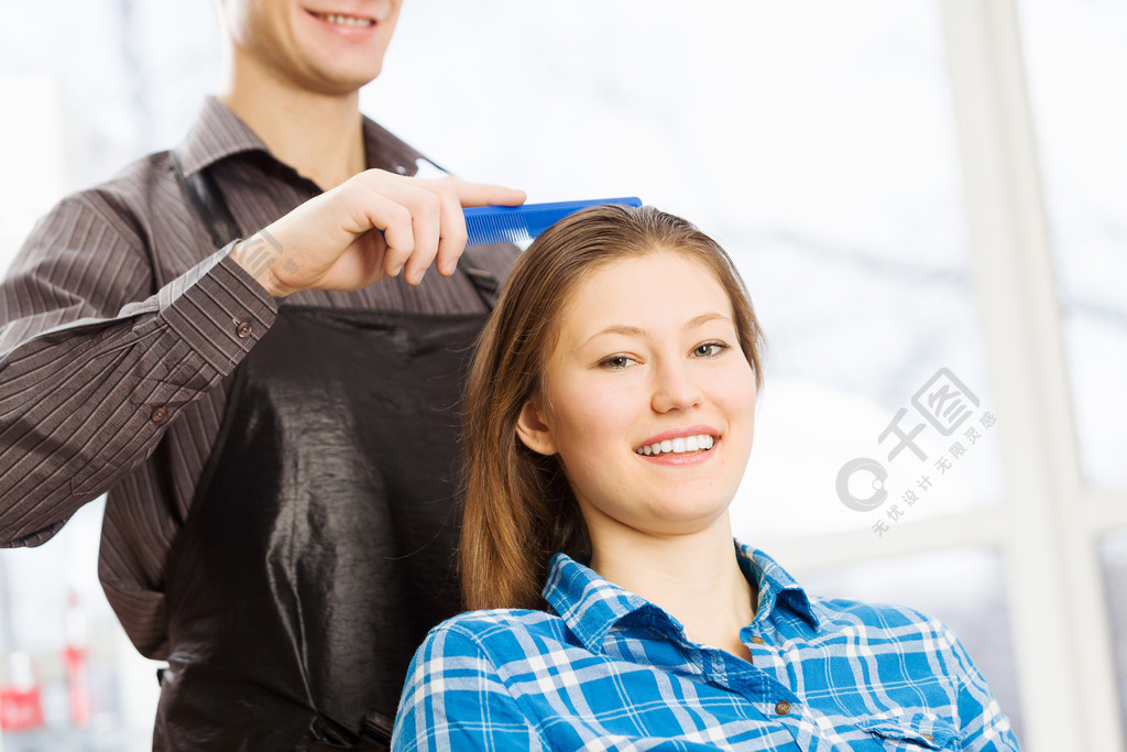 在美容院椅子上的年轻女子在理发师和男理发师