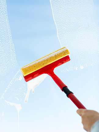 人，家<i>务</i>劳动和家<i>务</i>管理的概念— —用海绵拖把和泡沫的手清洁窗户玻璃的特写