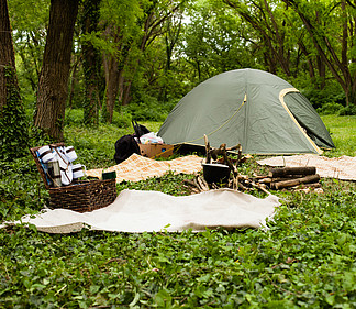 与旅游绿色野营的帐篷和锅在森林里的室外露营地在火上野餐一天娱乐和户外旅行的概念