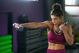 猛击和拳击与哑铃的运动的<i>妇</i><i>女</i>在健身房努力锻炼和训练健身概念运动的<i>女</i>人冲和拳击与哑铃