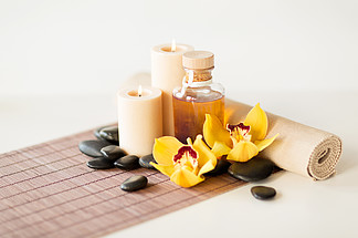 水疗，健康和美容的概念— —精油，按摩石，蜡烛和兰花的特写