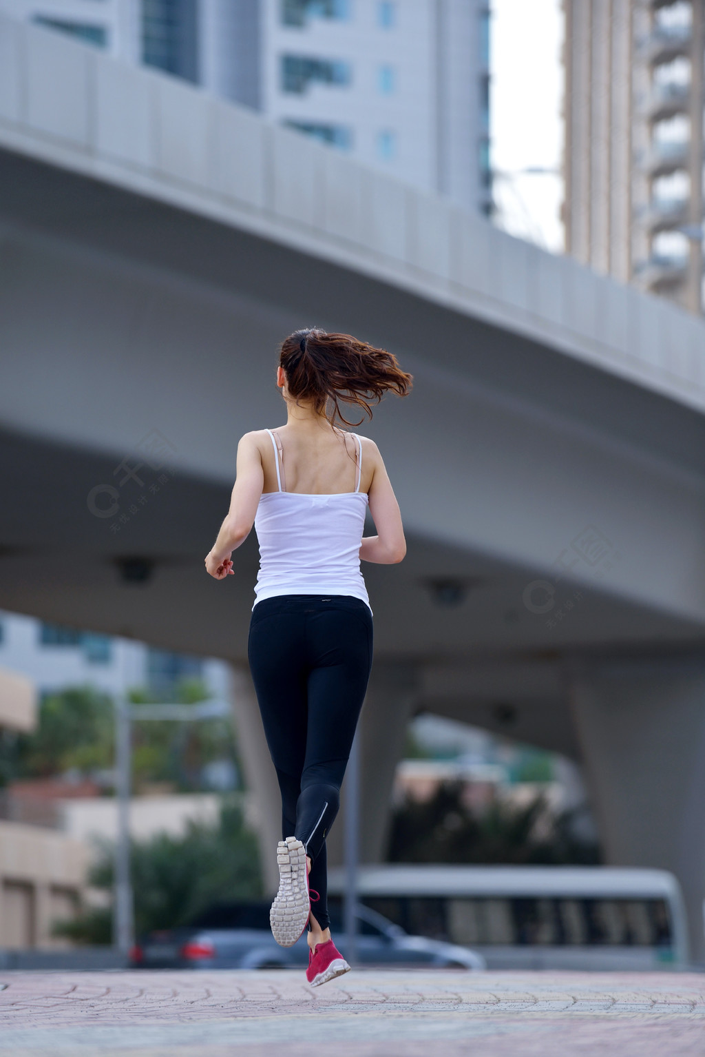 在城市公園跑步女子賽跑者外面慢跑在早晨與迪拜城市場景在背景中1年