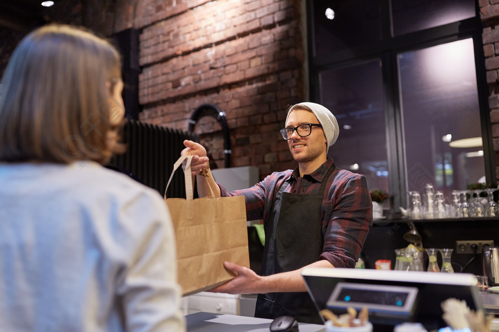 小型企业食品人和服务理念快乐的女性顾客从人或男服务员拿纸袋在素食