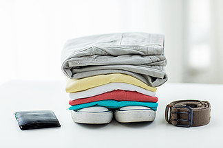 衣服和私人人员的概念— —在家折叠桌上的衬衫，裤<i>子</i>，皮带，钱包和鞋<i>子</i>