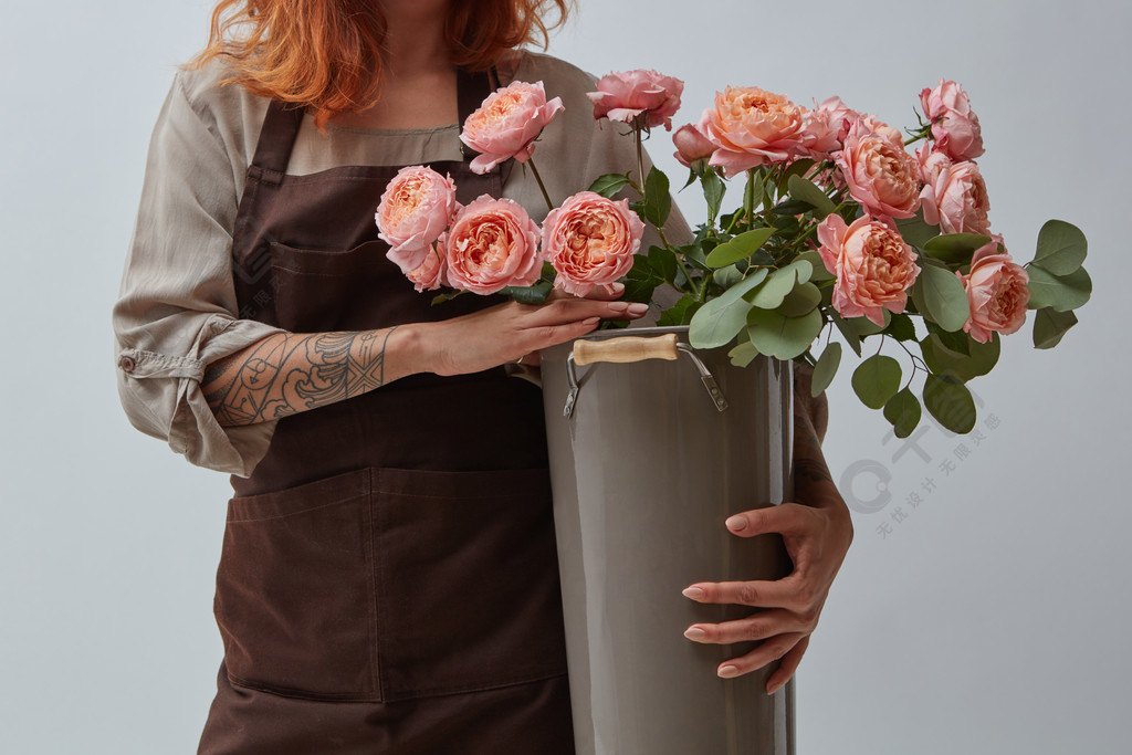粉红色的媒体玫瑰母亲节花店的概念女孩抱着一个花瓶,一束玫瑰花