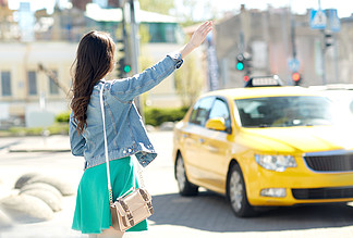 手势，运输，旅行，旅游和人们观念-年轻女子或少女在城<i>市</i>的街道上搭出租车或搭便车