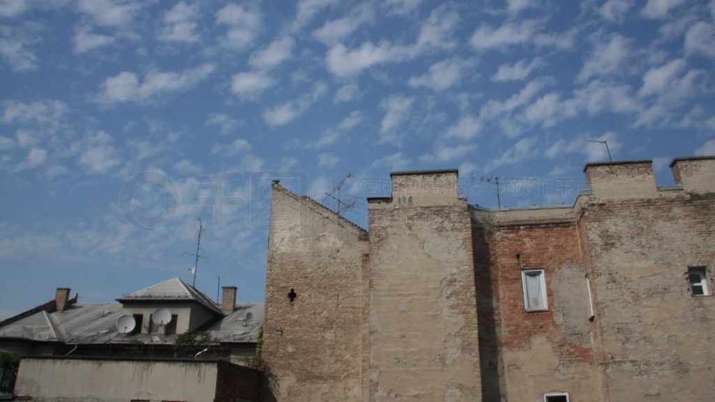 Wolken im Zeitraffer nber einer HSuserfront bei blauem Himmel