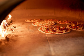 食品，意大利厨房和烹饪的概念— —在比萨店在烤箱里烤的比萨披萨店在烤箱里烤比萨