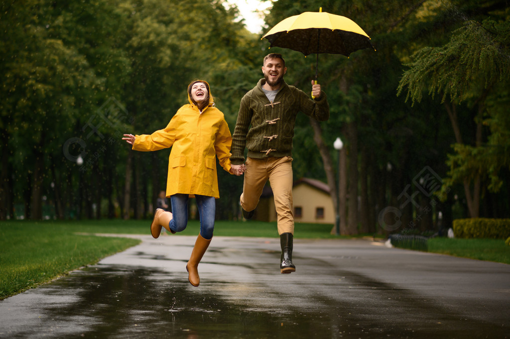 爱情情侣跳像一个孩子在公园里夏天的雨天男人和女人在雨中的雨伞下