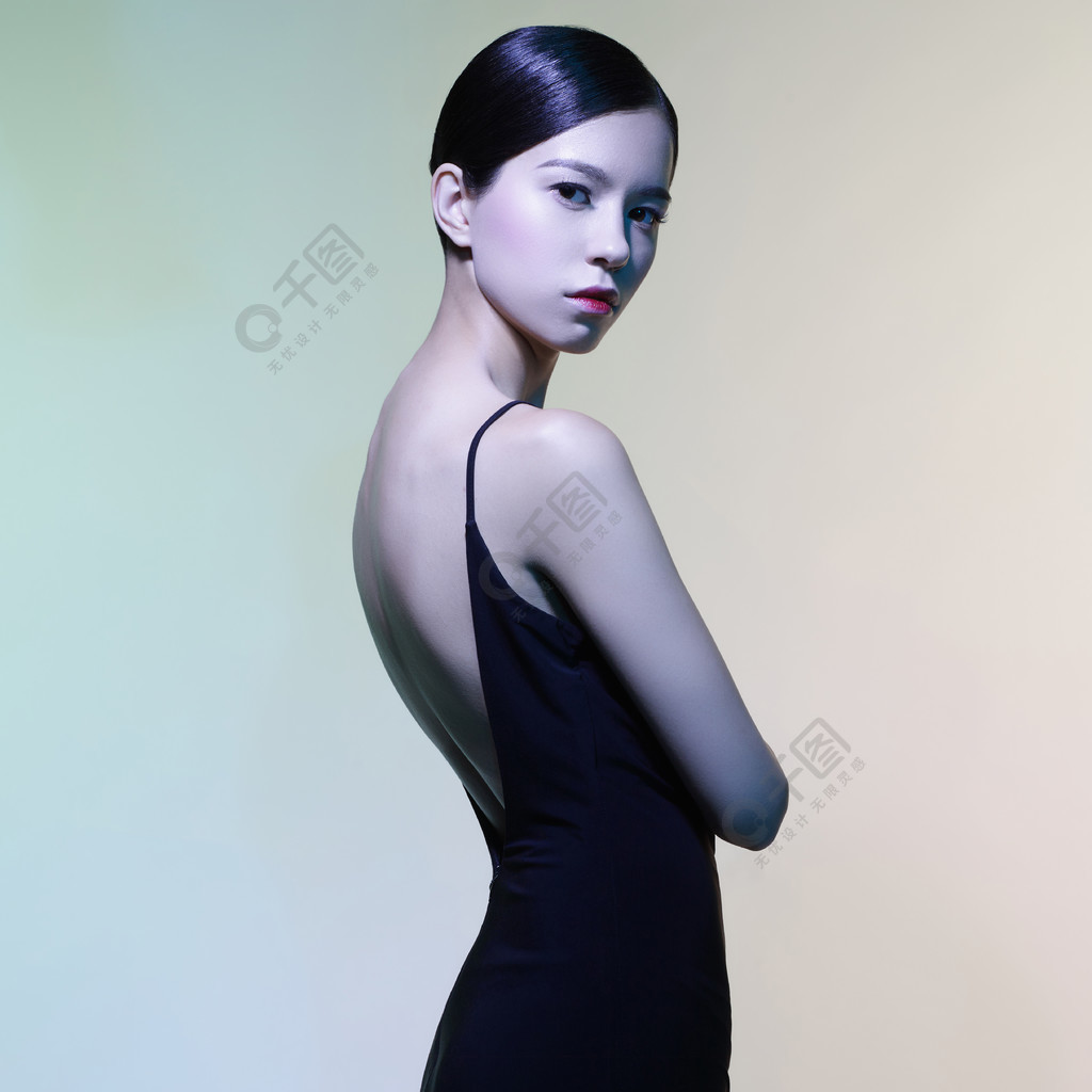塑造美丽的妇女演播室画象黑礼服的在五颜六色的背景亚洲美女