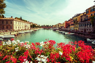 Peschiera与小船和被弄脏的大竺葵花的del加尔达五颜六色的镇开花该城市位于拉各迪加尔达湖，威尼斯，意大利，欧洲东部佩斯基耶拉德尔加尔达五颜六色的镇在意大利
