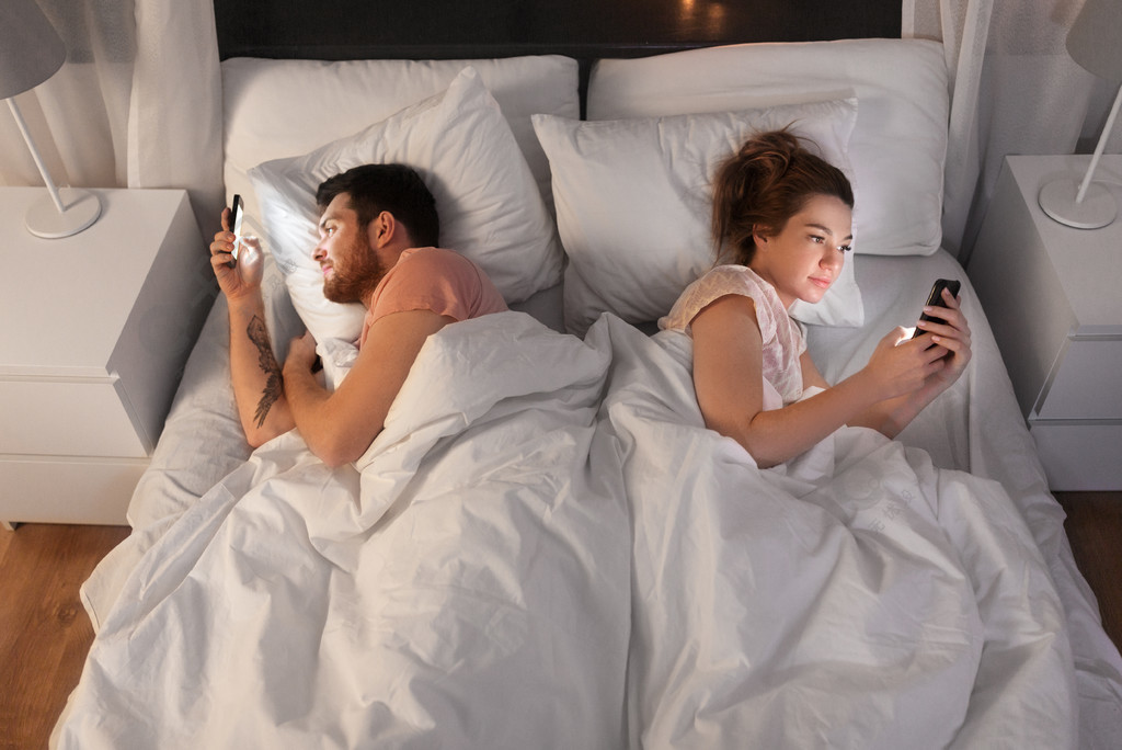 技术互联网和通信的概念晚上在床上使用智能手机的夫妇夫妇在晚上在床