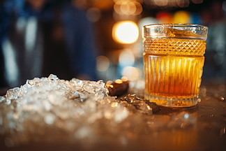 在玻璃和冰的<i>布</i><i>朗</i>饮料在酒吧抵抗特写镜头，没人提神酒精饮料，桌上的冷晶体棕色饮料杯和冰在酒吧柜台
