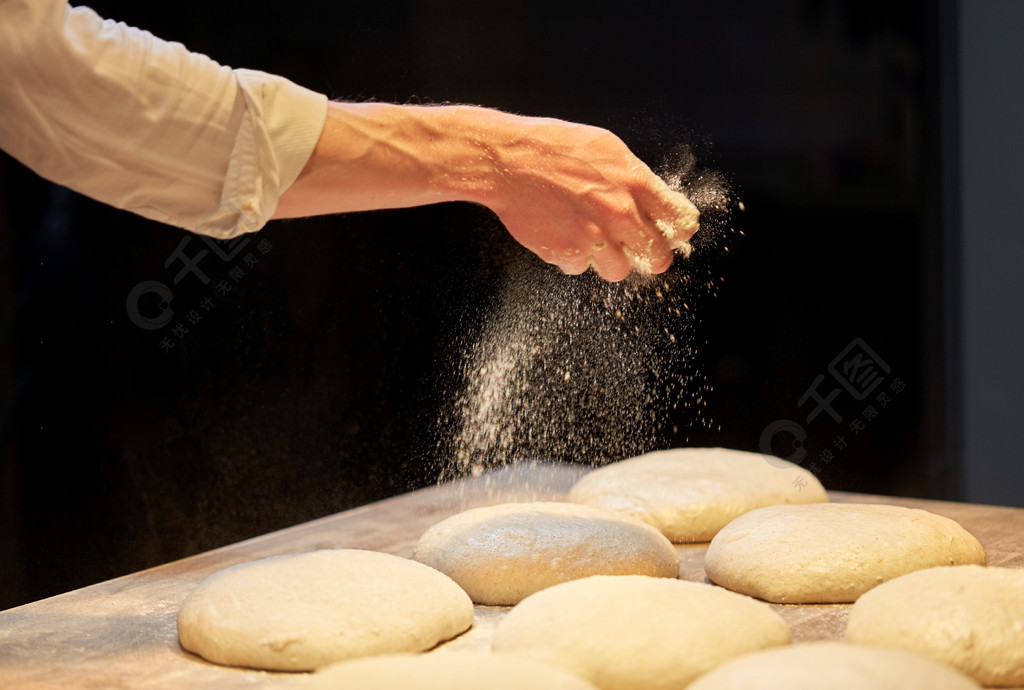 食品烹饪，烘烤和人们观念-做面包和倒面粉到面团在面包店的厨师或面包师厨师或贝克在面包店做面包面团
