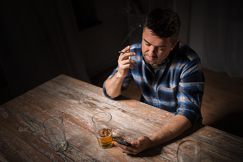 手机在晚上喝啤酒和抽烟手机喝酒和吸烟的年轻人手机喝酒和抽烟的男人