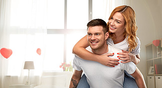 爱，情人节和关系概念-愉快的夫妇画象在获得白色的T恤杉的在用心形的气球背景装饰的家庭娱乐室幸福夫<i>妻</i>爱在情人节开心