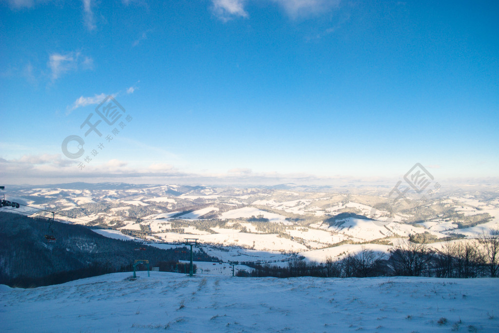 风吹雪覆盖的山峰和远处的一座木房子山中的雪风