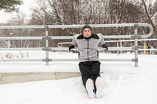 健身，运动，人，锻炼和健康的生活方式的概念— —年轻人做肱<i>三</i><i>头</i>肌蘸和热身在冬天的栅栏