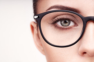与长的睫毛的女性眼睛在镜片眼镜模型视力矫正视力差眼镜架化妆，化妆品，美容特写，宏