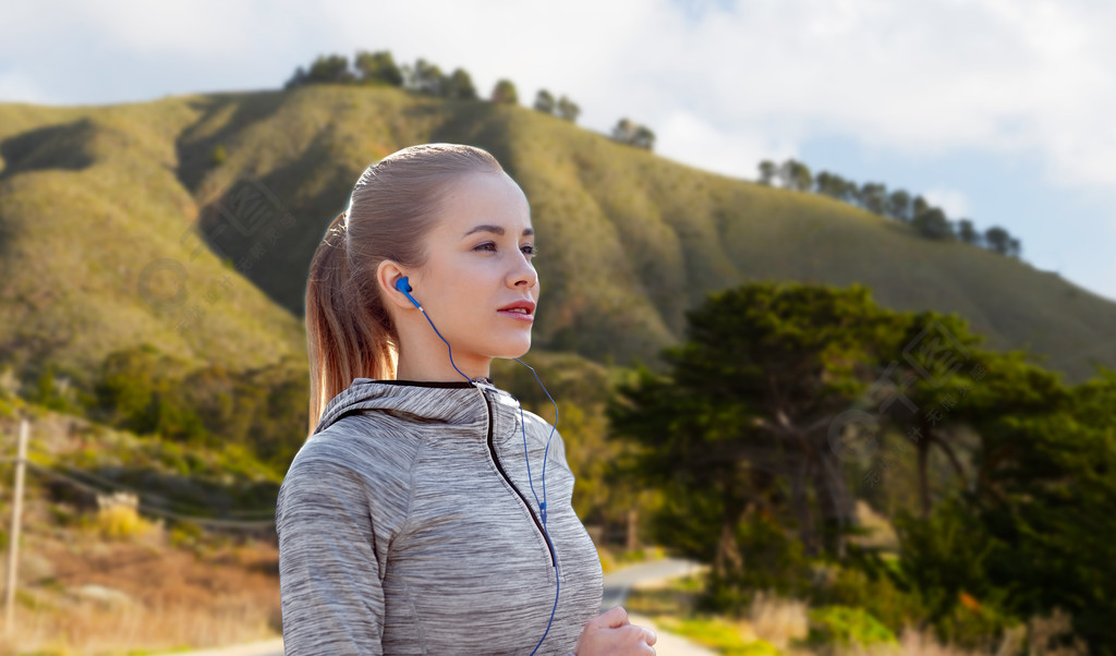 健身體育和技術的概念幸福的女人跑和聽音樂的耳機在加州大sur小山