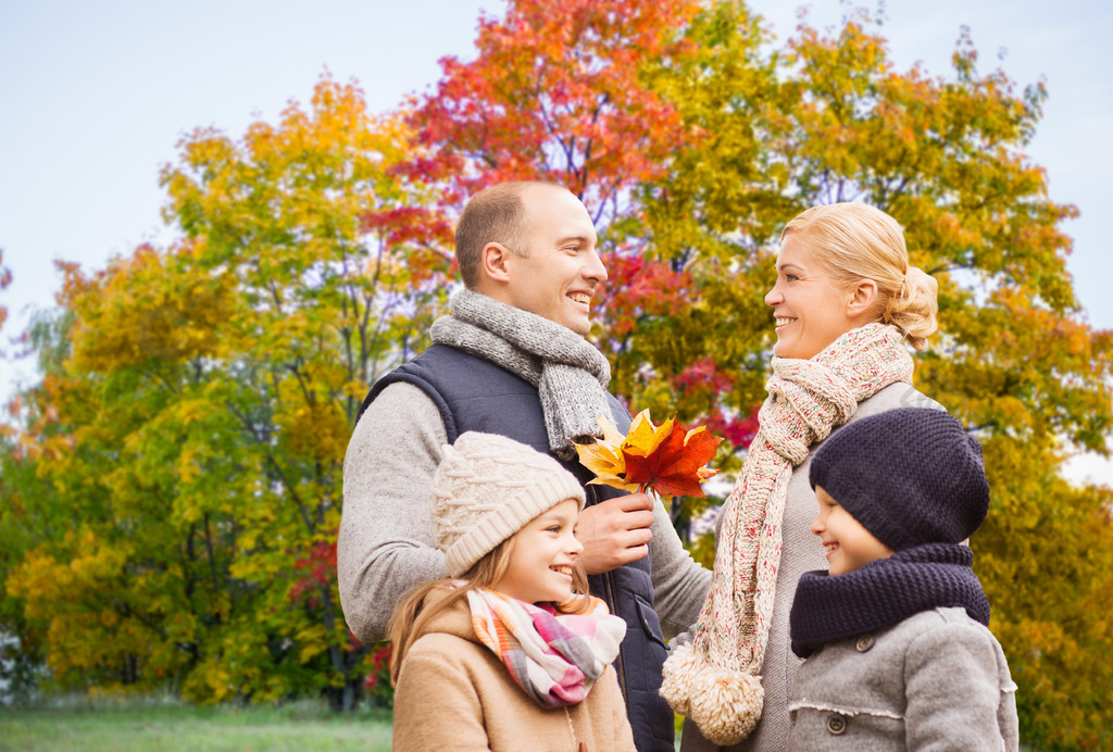 父亲,女儿和儿子幸福的家庭,在秋天的公园背景