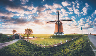 在日出的风车在荷兰与传统的荷兰风车，绿草，围栏和多彩的天空有云惊人的观点乡村景观与复古色调农村景象在夏季旅行