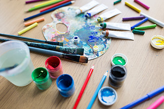 美术，创造力和艺术工具的概念— —调色板，画笔，油漆管和桌上的水粉颜色桌子上的调色板，刷子和油漆管