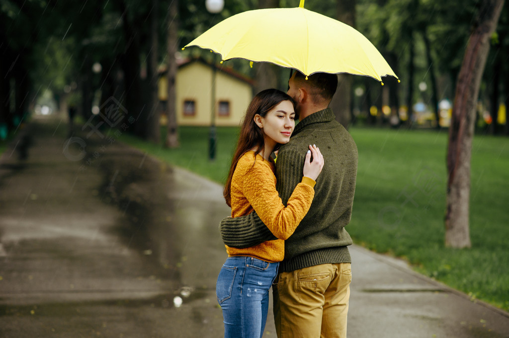 愛夫婦在公園,夏天雨天擁抱男人和女人站在傘下,在人行道上的浪漫約會