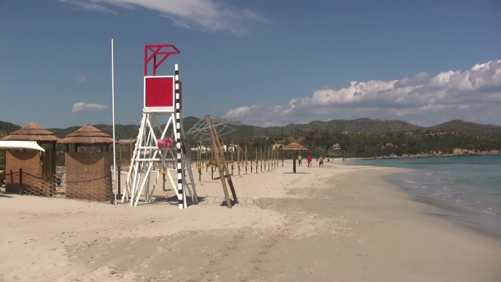 Blick nber den Strand mit einem Turm fnr StrandwSchter auf ein blaues Meer hinaus