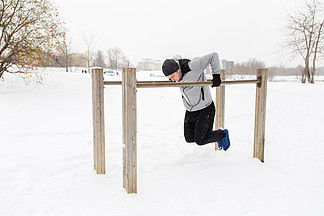 健身，运动，锻炼，训练和人的概念— —做肱<i>三</i><i>头</i>肌的年轻男子在冬天在双杠上蘸