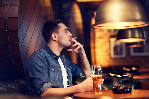 一个抽烟的商人的轮廓剪影男人抽雪茄并释放烟雾
