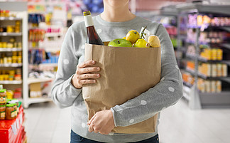 购物，健康饮食和生态友好的概念— —关闭纸袋装满了在超市背景下的食物的女人纸袋装满食物的女人的特写