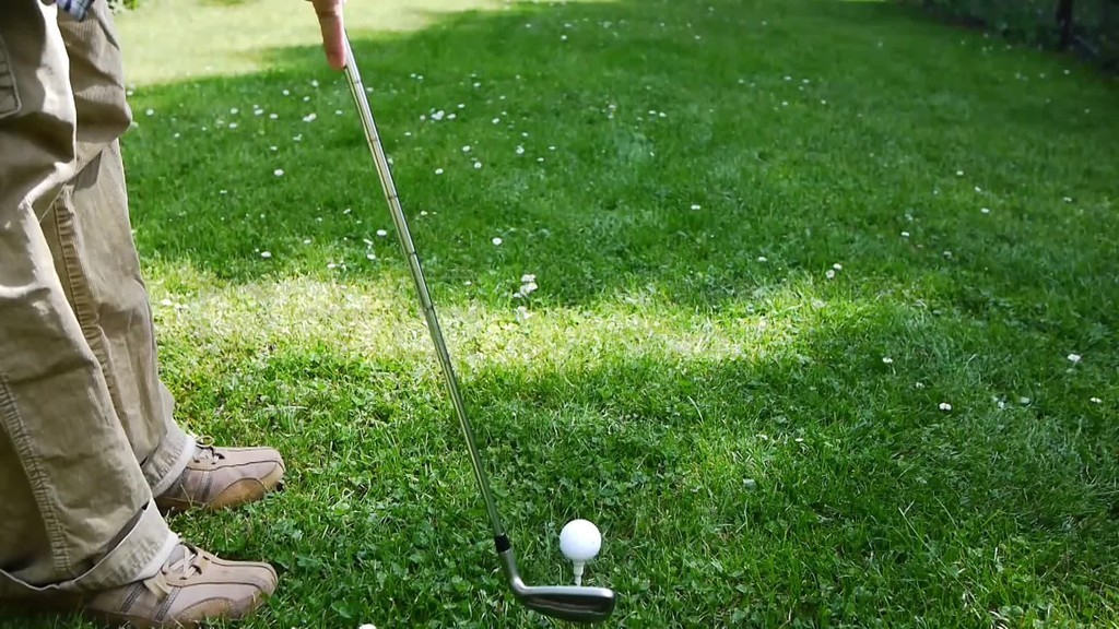 Ein Mann Zielt mit dem Golfschlager auf einen GolfballTrifft Ihnder Ball fliegtרעڴ߶ڷ