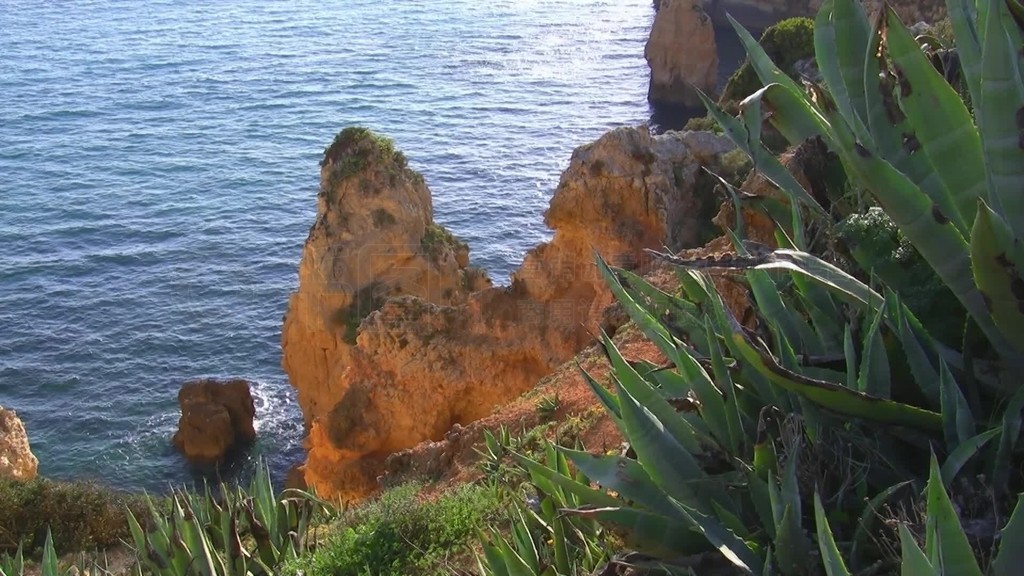 Blick von mit grunen BuschenGras und Kakteen bewachsenen Felsen auf das Meer und Felsengebilde Ste