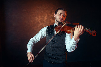 演奏在小提琴的男性提琴手画象古典<i>音</i><i>乐</i>有<i>乐</i>器的小提琴手的人男提琴手在小提琴上演奏古典<i>音</i><i>乐</i>