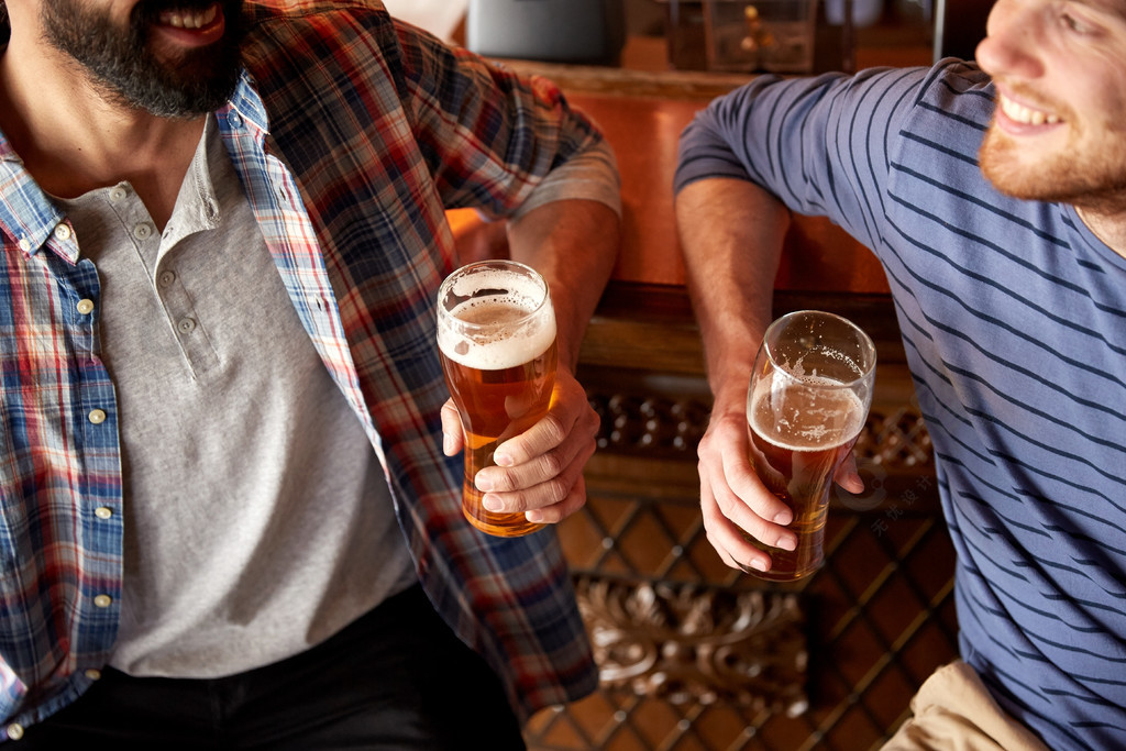 人,男人,休闲,友谊和沟通的概念— —在酒吧或酒馆喝啤酒的快乐男性