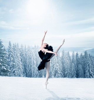 舒展优美的女跳芭蕾舞者,背景的冬天多雪的森林