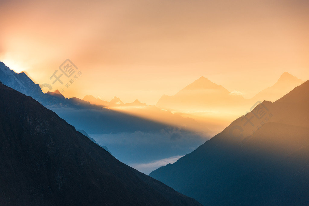 雄偉的山脈和低雲的輪廓,在尼泊爾多彩日出的景色景觀與喜馬拉雅山脈