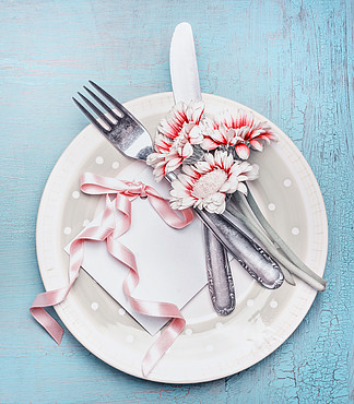 在淡色的可爱的桌餐位餐具与板材，利器，花和卡片与丝带在土耳其玉色破旧的别致的背景，顶视图模拟母亲节假期，婚礼，生日