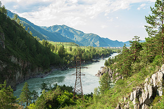 在美好的山风景中的输电线与<i>水</i><i>流</i>在阿尔泰，西伯利亚，俄罗斯在美好的山风景中的输电线