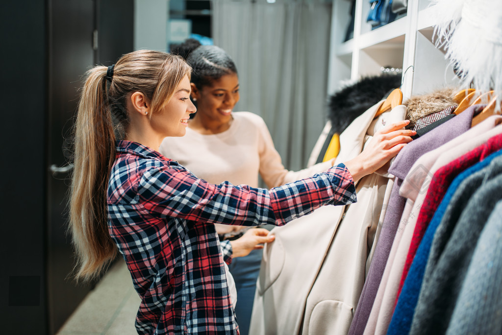 服装店的购物狂消费主义生活方式时尚在商店里挑选衣服的两个女友购物